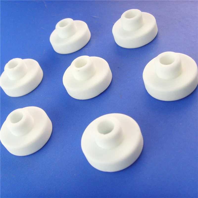 White steatite ceramic insulator beads and bushings on a blue background