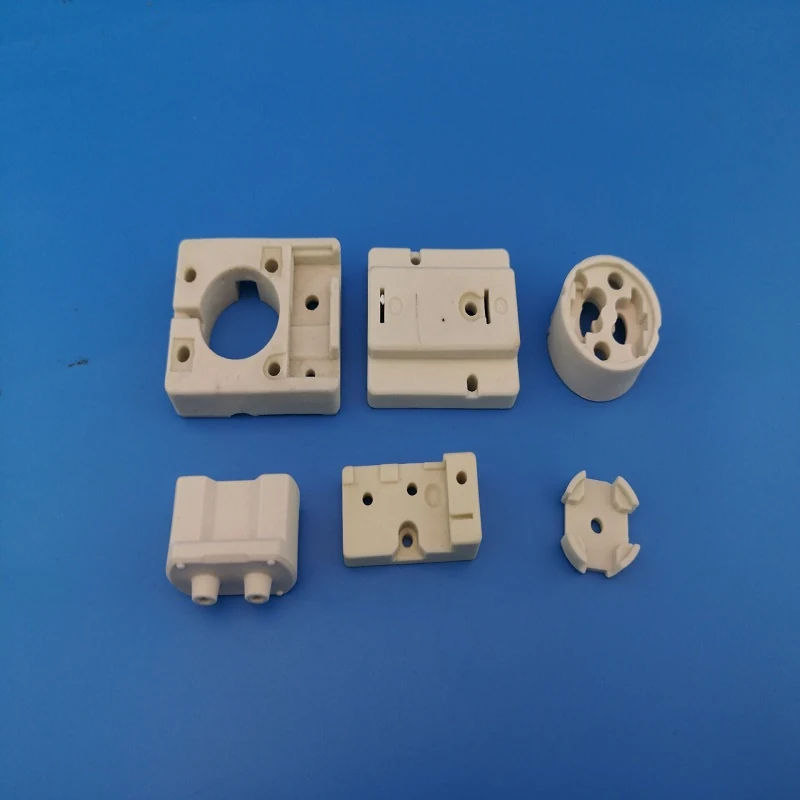Machined steatite ceramic insulator blocks and plates on a blue background