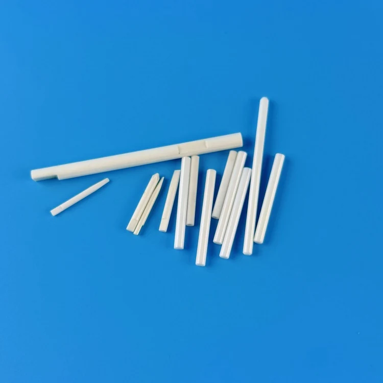 Thin white zirconia ceramic rods of different diameters on a blue background